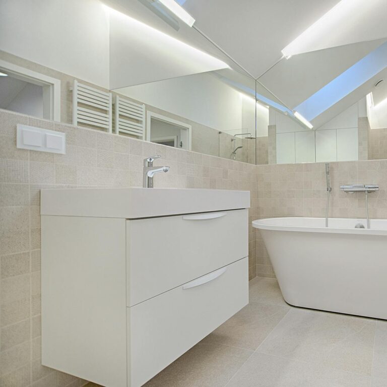 Elegant minimalist bathroom featuring a white bathtub and sleek fixtures.